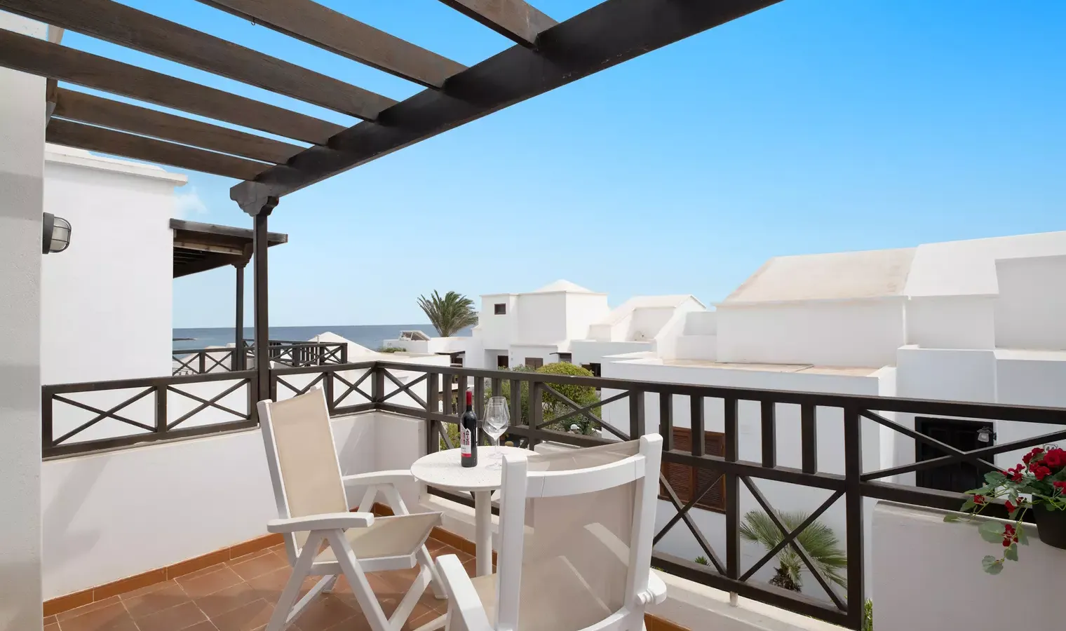 South-facing balcony at Casa Sol y Playa with sea view and pool visible below, Playa Honda, Lanzarote
