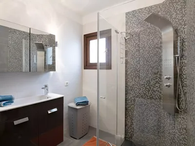 Modern bathroom at Casa Sol y Playa with walk-in shower and mosaic tiles
