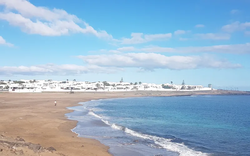 Playa La Concha, Playa Honda — calm sandy beach with clear water and residential buildings along the promenade