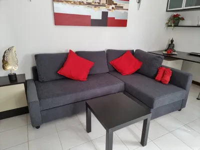 Living room at Casa Sol y Playa with grey corner sofa and red cushions