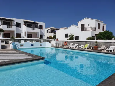 Shared pool with sunloungers at Casa Sol y Playa complex